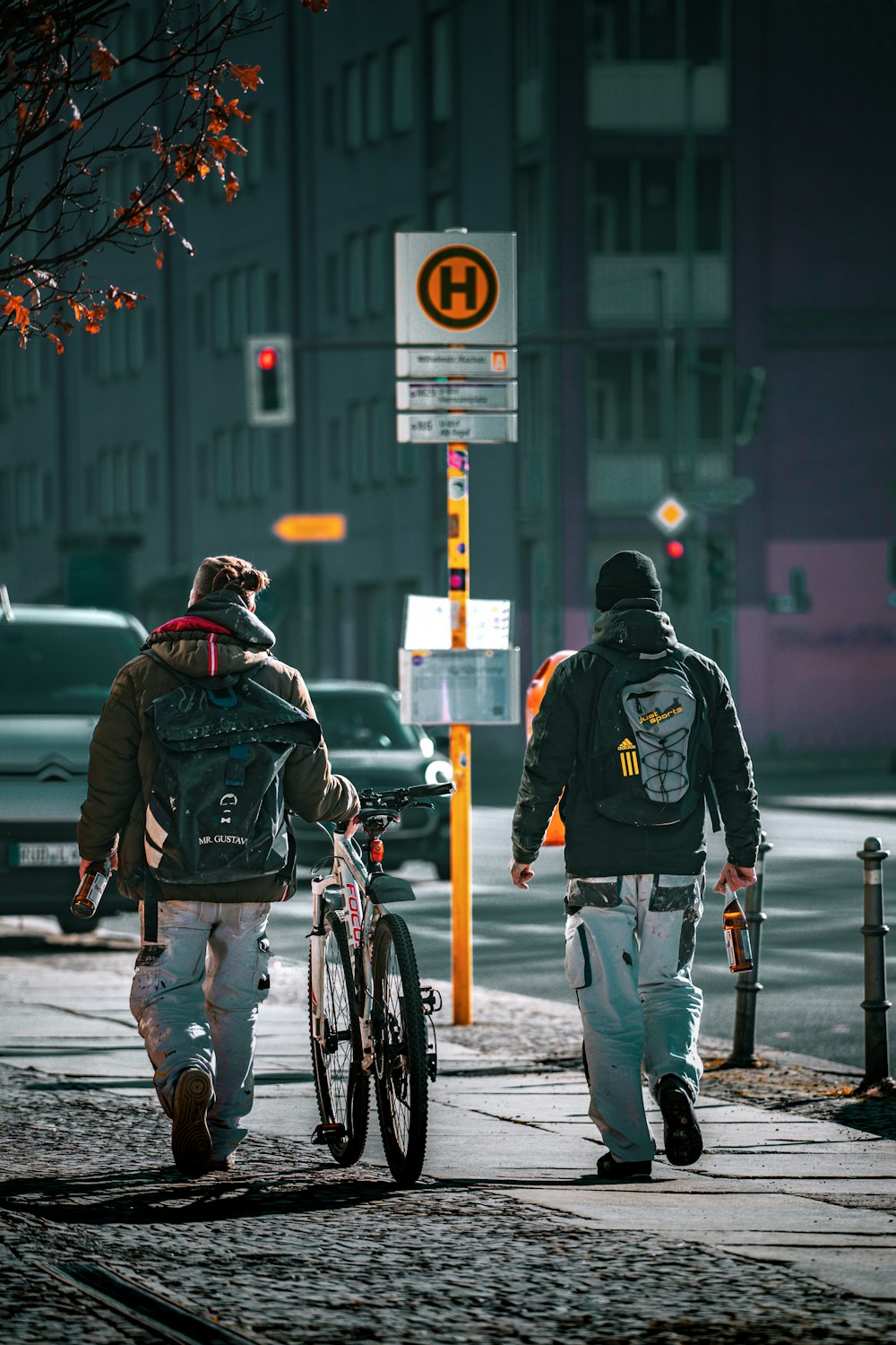 a couple of people walking down a street next to a bike