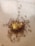 A group of small red ants swarms around a piece of yellow food on a light brown surface. The ants appear to be actively moving in various directions, suggesting a dynamic and busy scene.