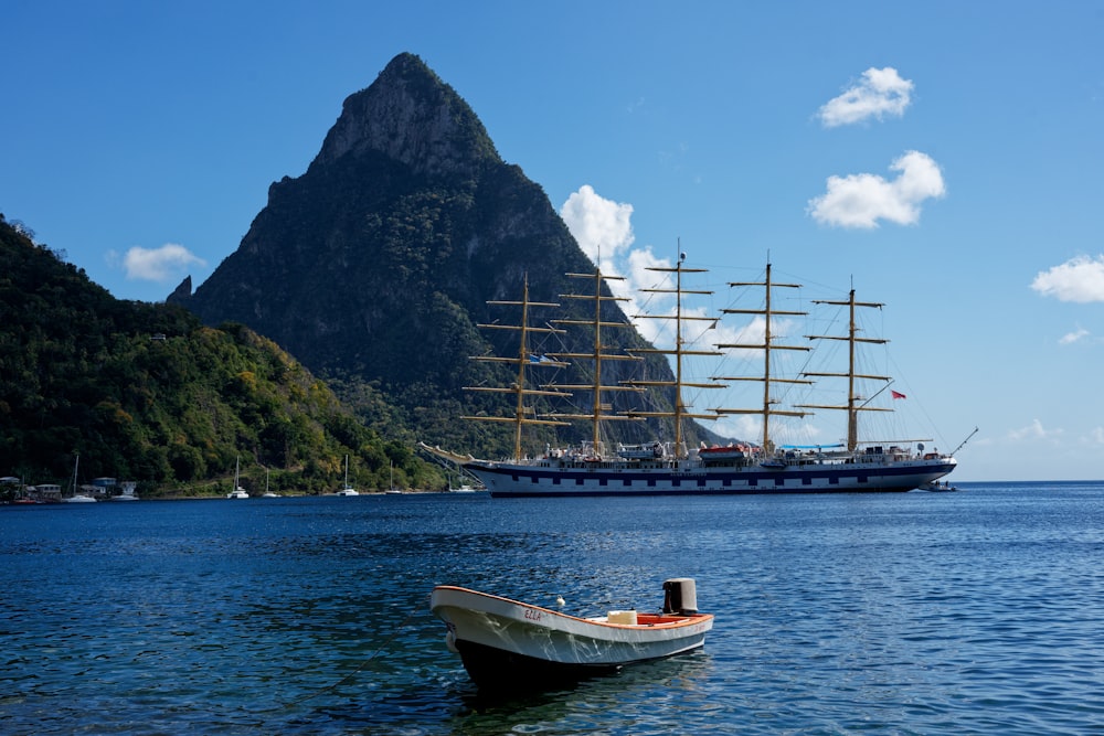 a boat floating on top of a body of water next to a mountain