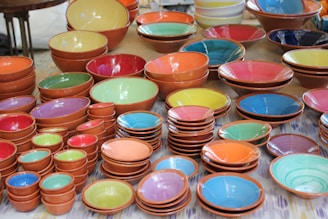 a table topped with lots of colorful bowls and plates