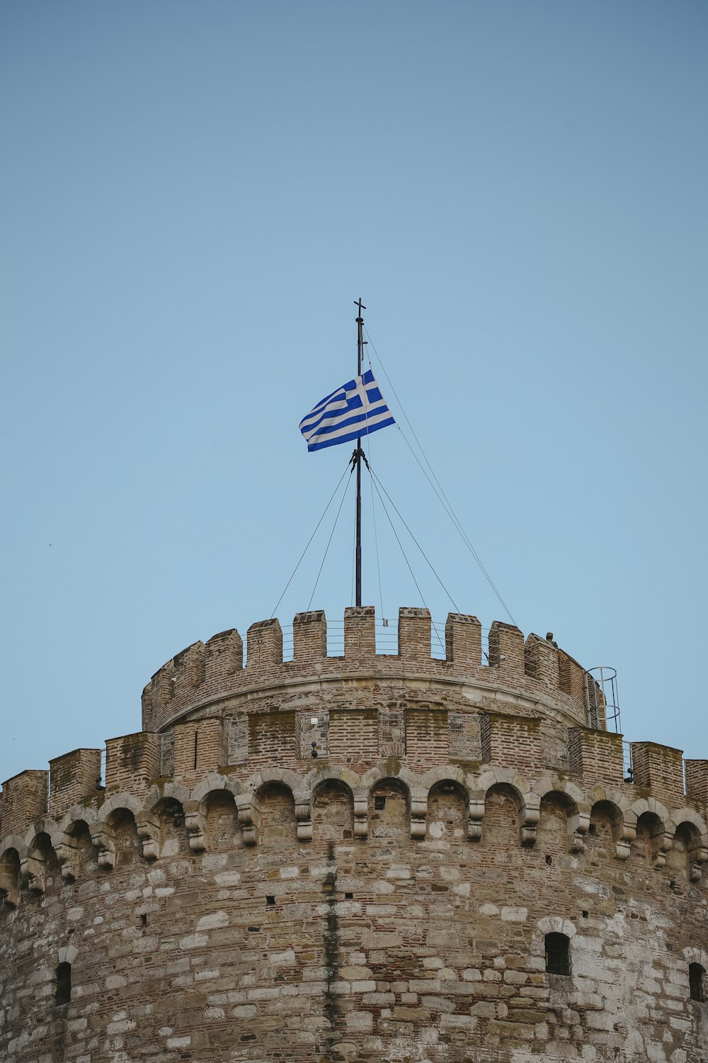 a flag on top of a building with a sky background