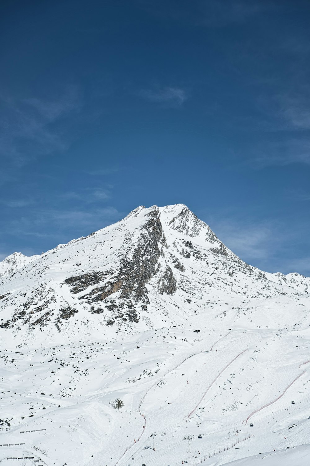 a snow covered mountain with ski tracks on it