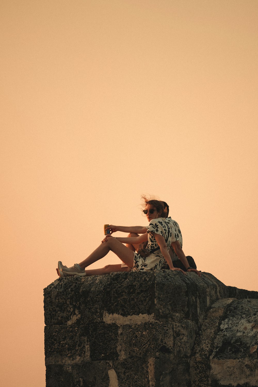 a couple of people sitting on top of a rock