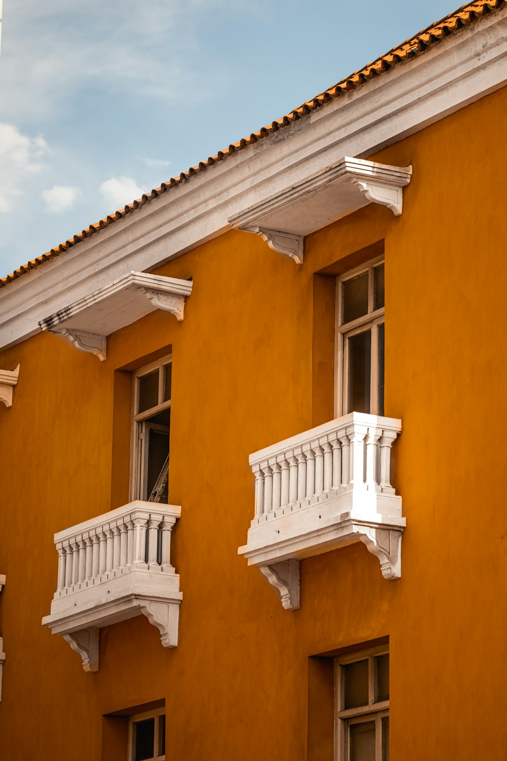 a yellow building with white balconies and windows