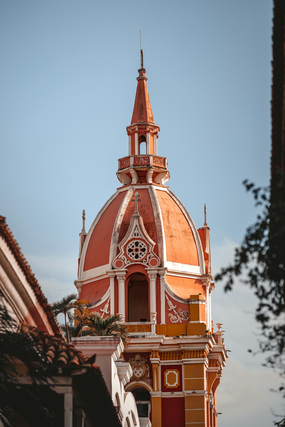 a large orange and white building with a clock on it's side