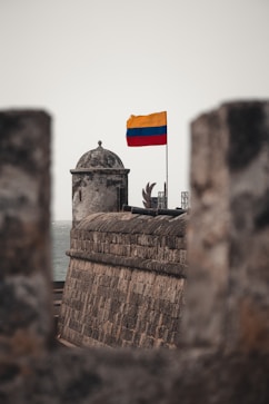 a flag on top of a building next to the ocean