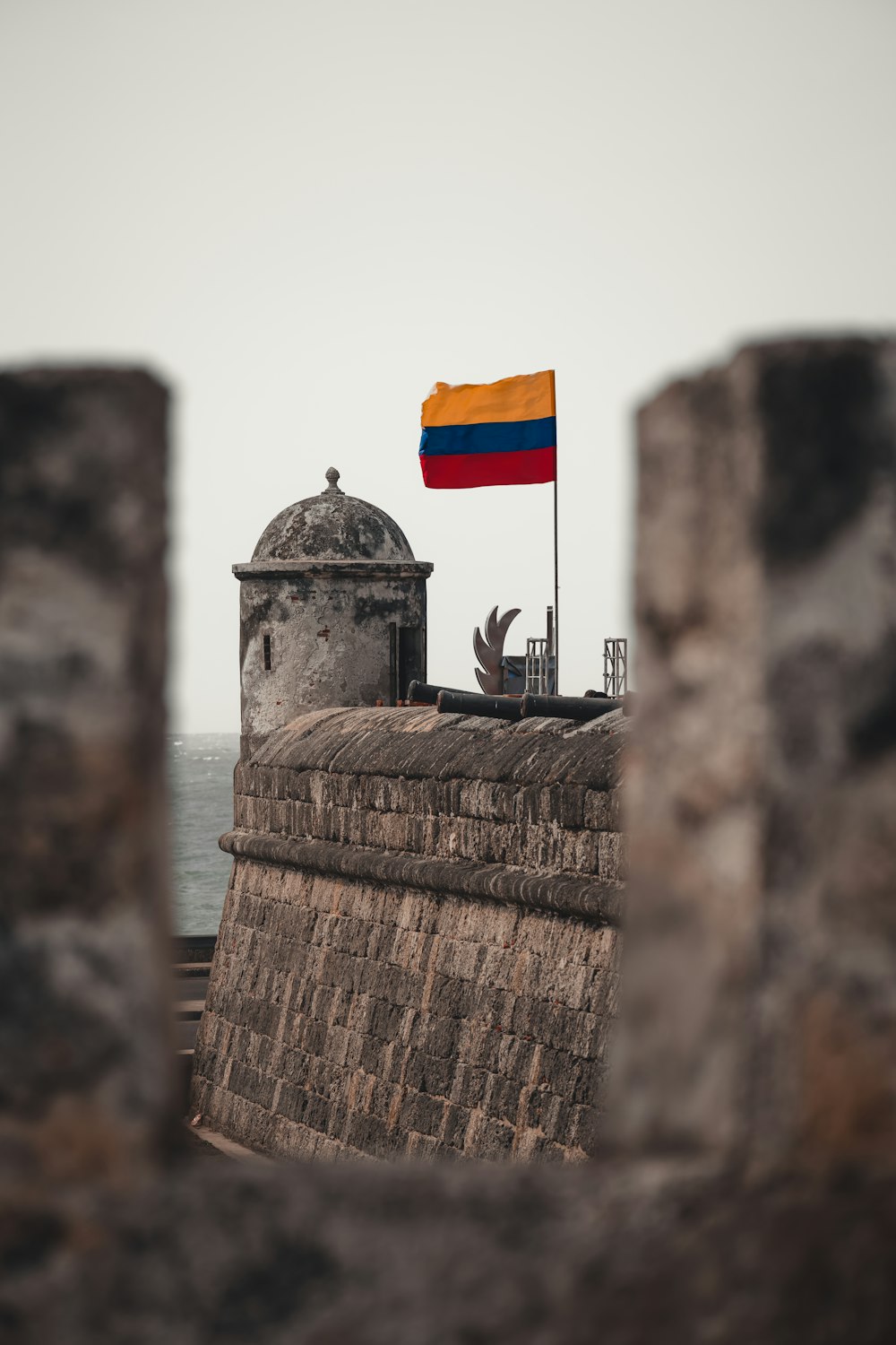 a flag on top of a building next to the ocean