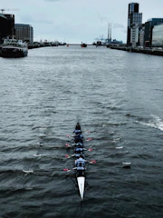 Coaches guiding players through intense training sessions on calm waters.