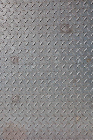 Concrete floor with a bold 3D printed diamond plate texture, blending industrial style with artistic flair.
