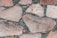 Large irregular stone slabs of various sizes are meticulously arranged with dark mortar visible in between, forming a rustic and textured pattern.