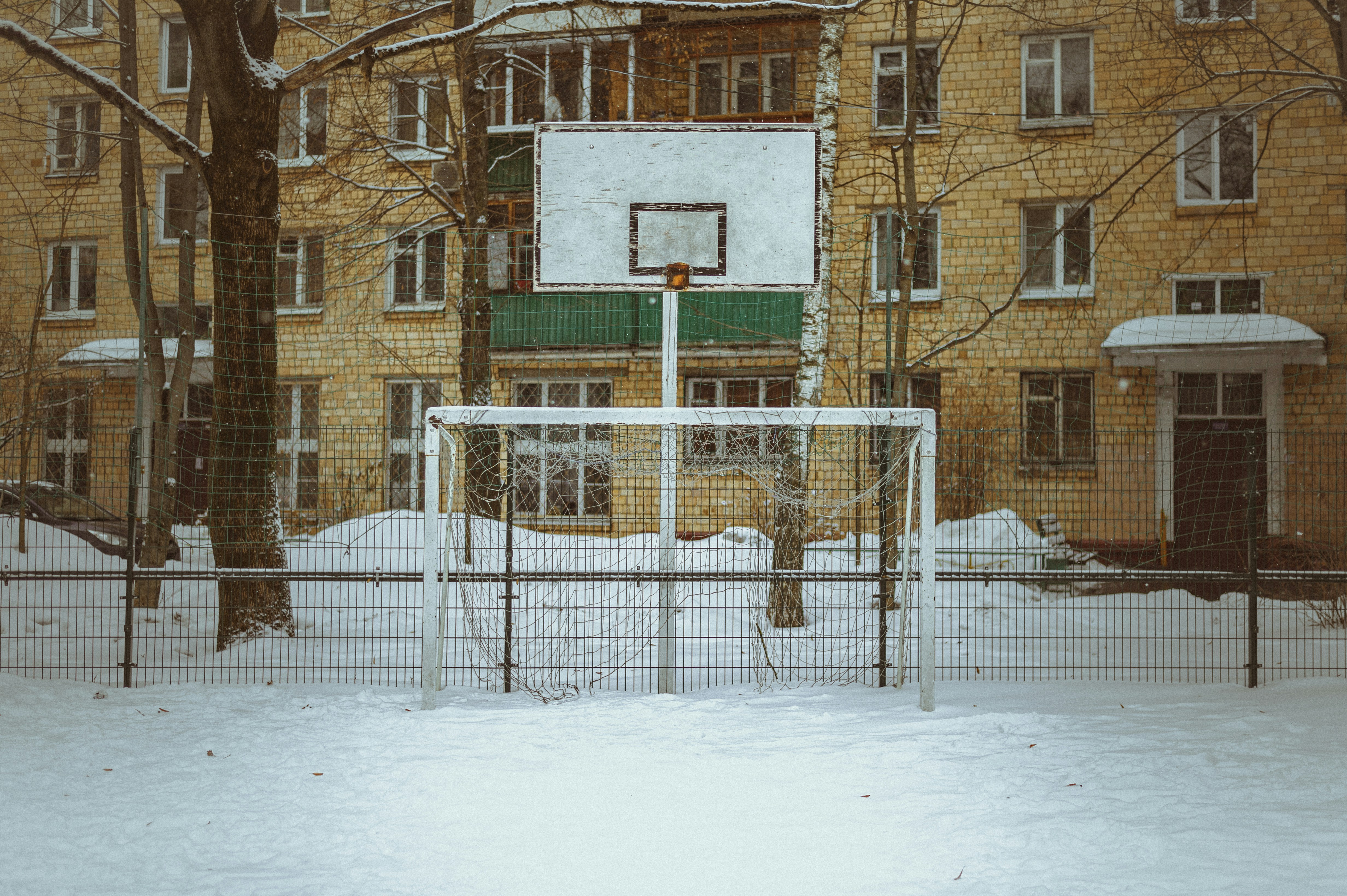 Playground in the yard of an apartment building. Winter, snow.