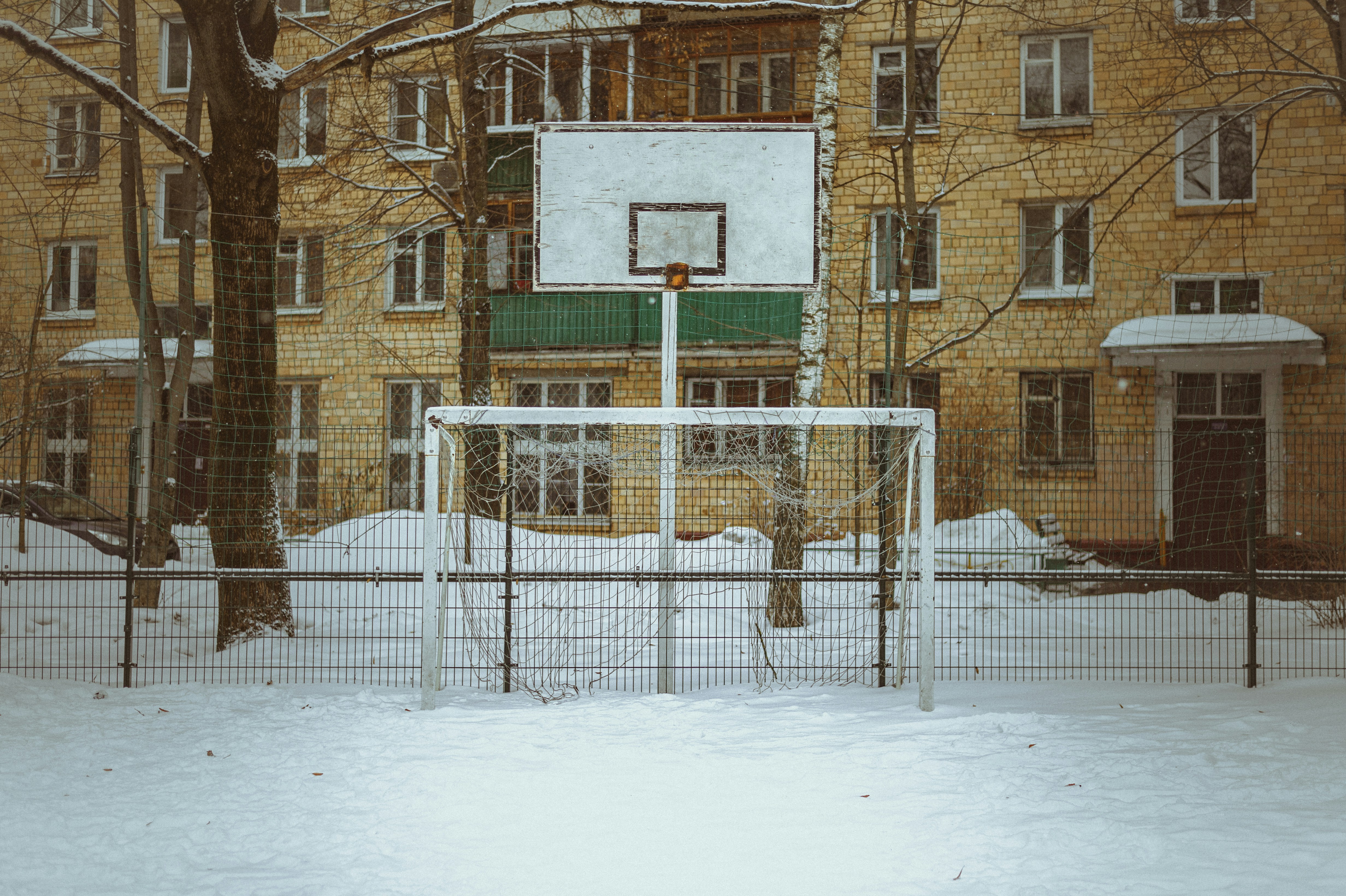 a basketball court in the middle of a snowy yard