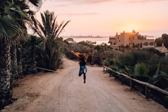 a person jumping in the air on a dirt road