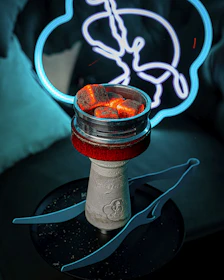 Elegant gold-accented hookah set on a charcoal surface with soft glowing light highlighting its curves.
