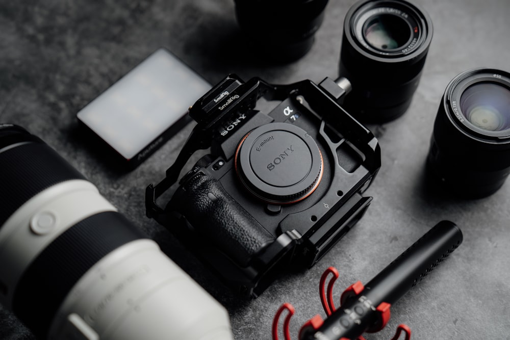 a camera, a camera lens, a pen, and other items on a table