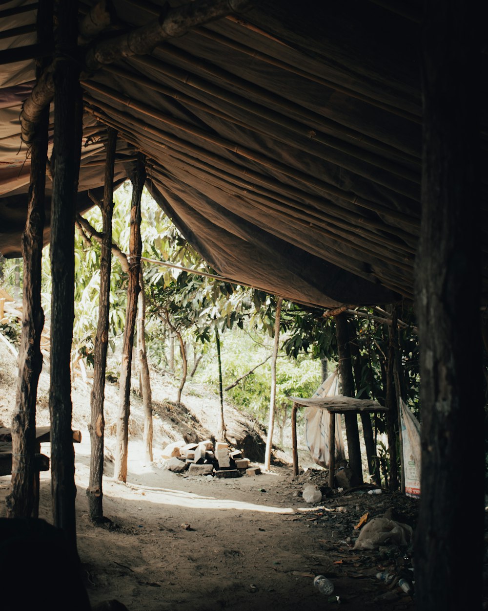 a group of people sitting under a tent in a forest