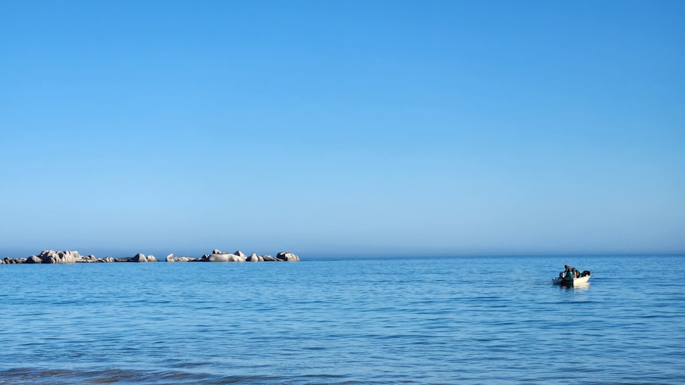 a person in a small boat in the middle of the ocean