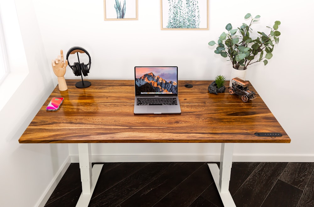 a desk with a laptop and headphones on it