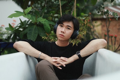 A peaceful scene of someone meditating outdoors with headphones on, surrounded by nature.