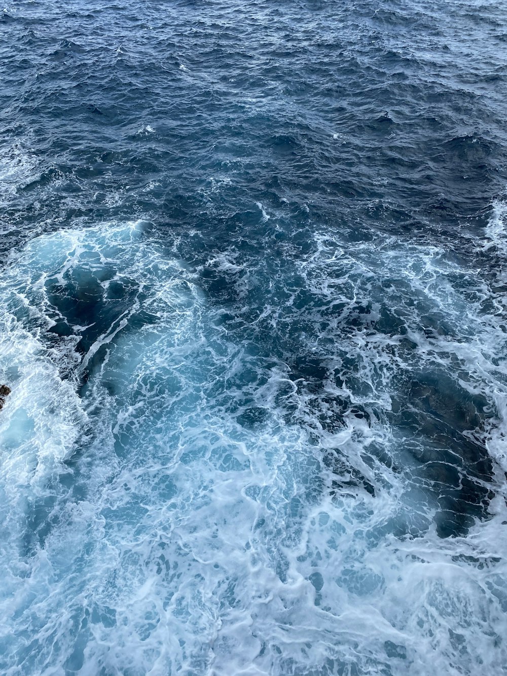 a couple of people riding on top of a boat in the ocean