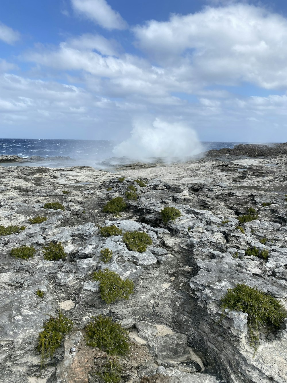 a rocky area with a body of water in the distance