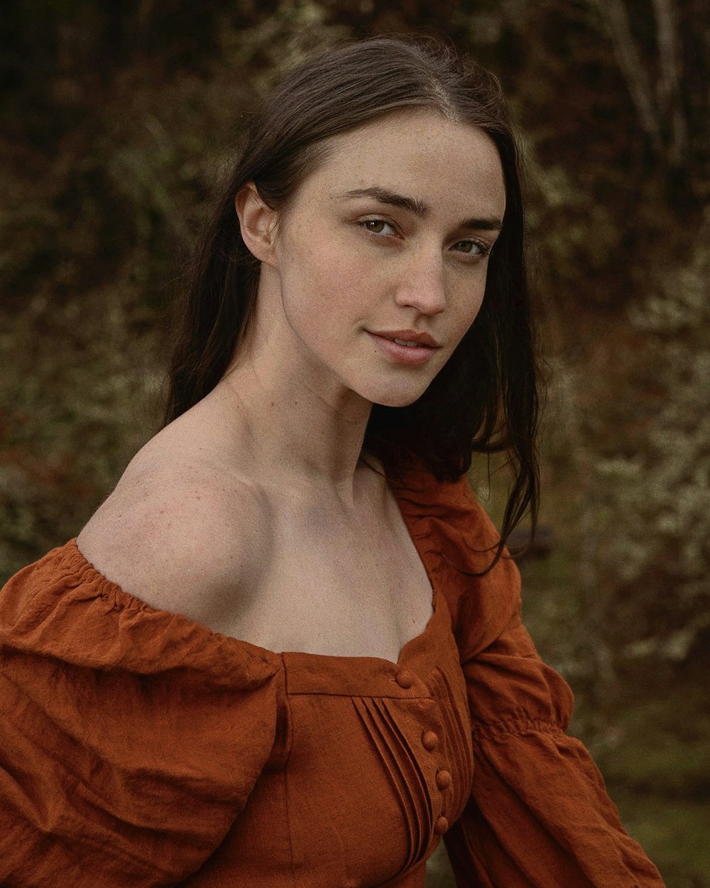 a woman in an orange dress posing for a picture