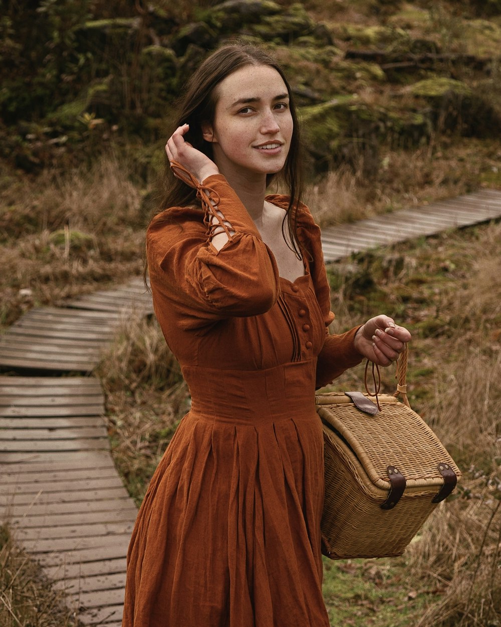 a woman in an orange dress is holding a basket