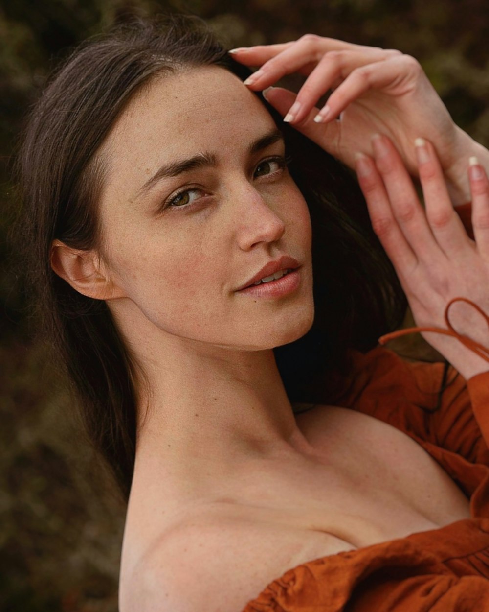 a close up of a person wearing a brown shirt