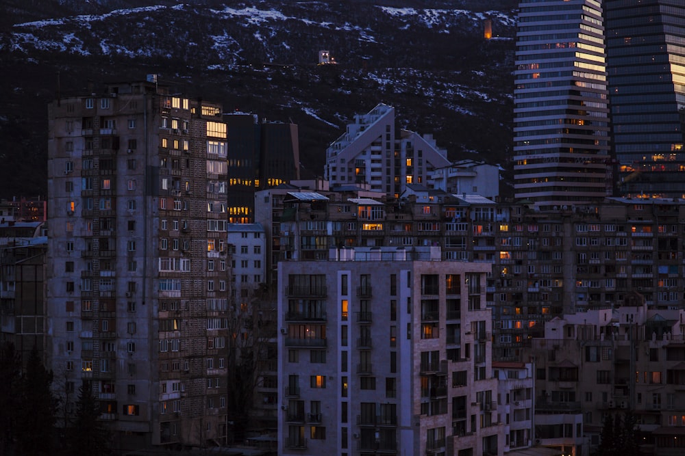 Una vista di una città di notte con le montagne sullo sfondo