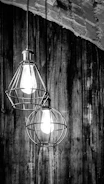 Industrial cage pendant lights hanging over a rustic kitchen island, blending style and function.