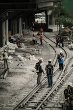 a group of people standing on top of train tracks