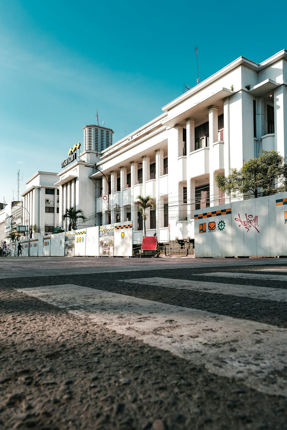 um grande edifício branco sentado ao lado de uma estrada