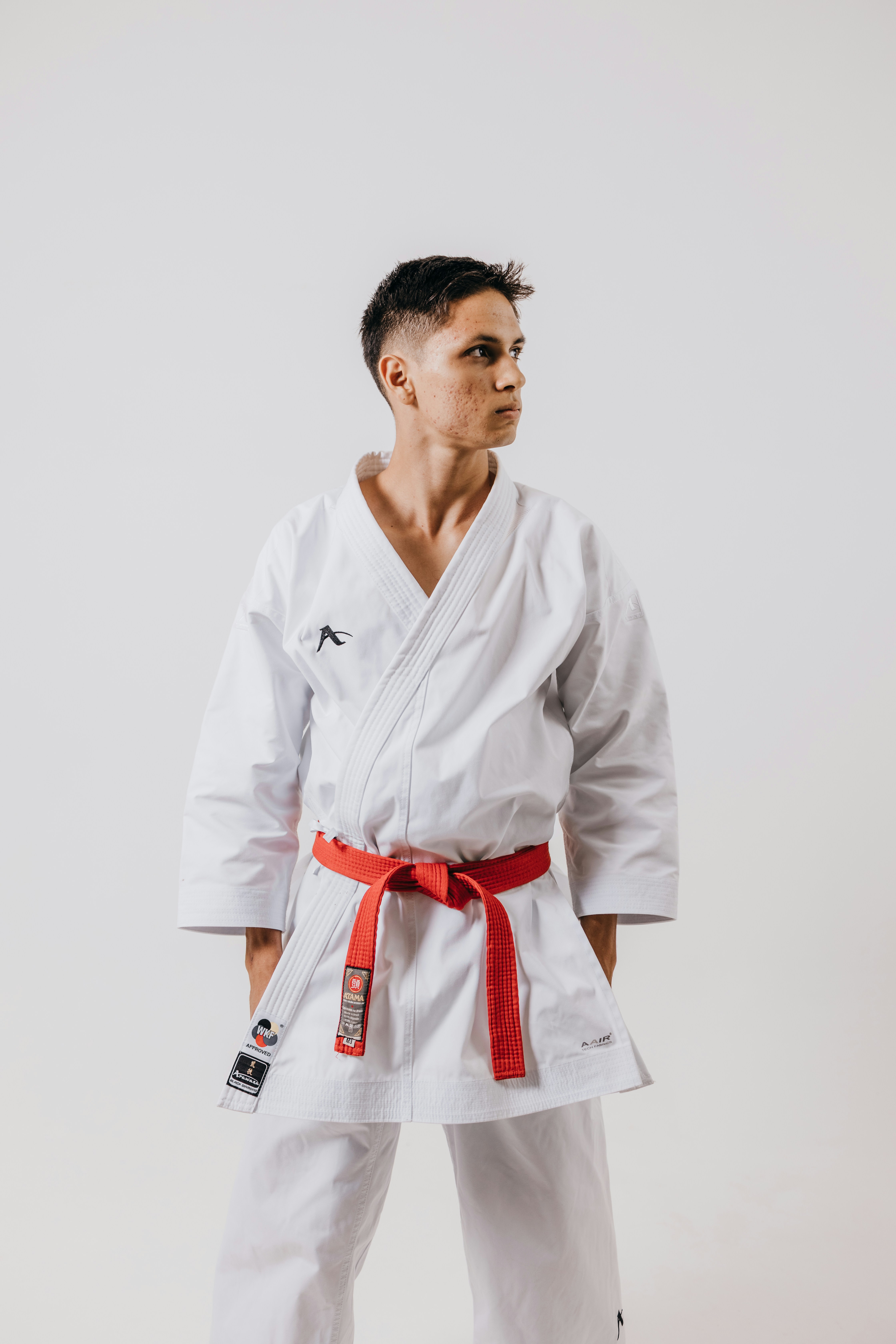 a man in a white karate suit with a red belt