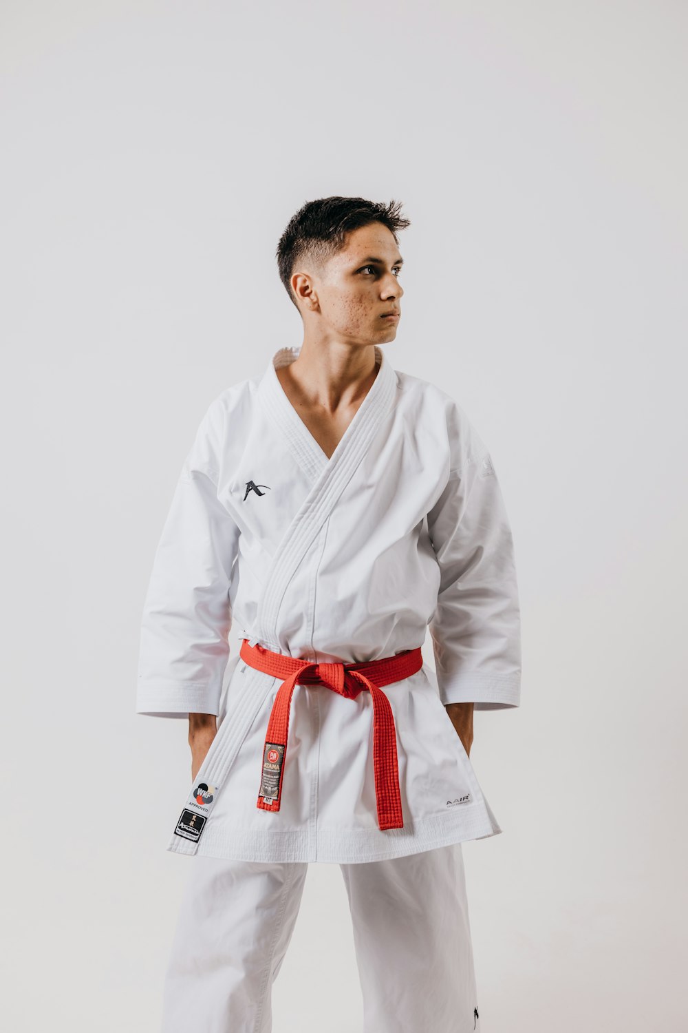 a man in a white karate suit with a red belt