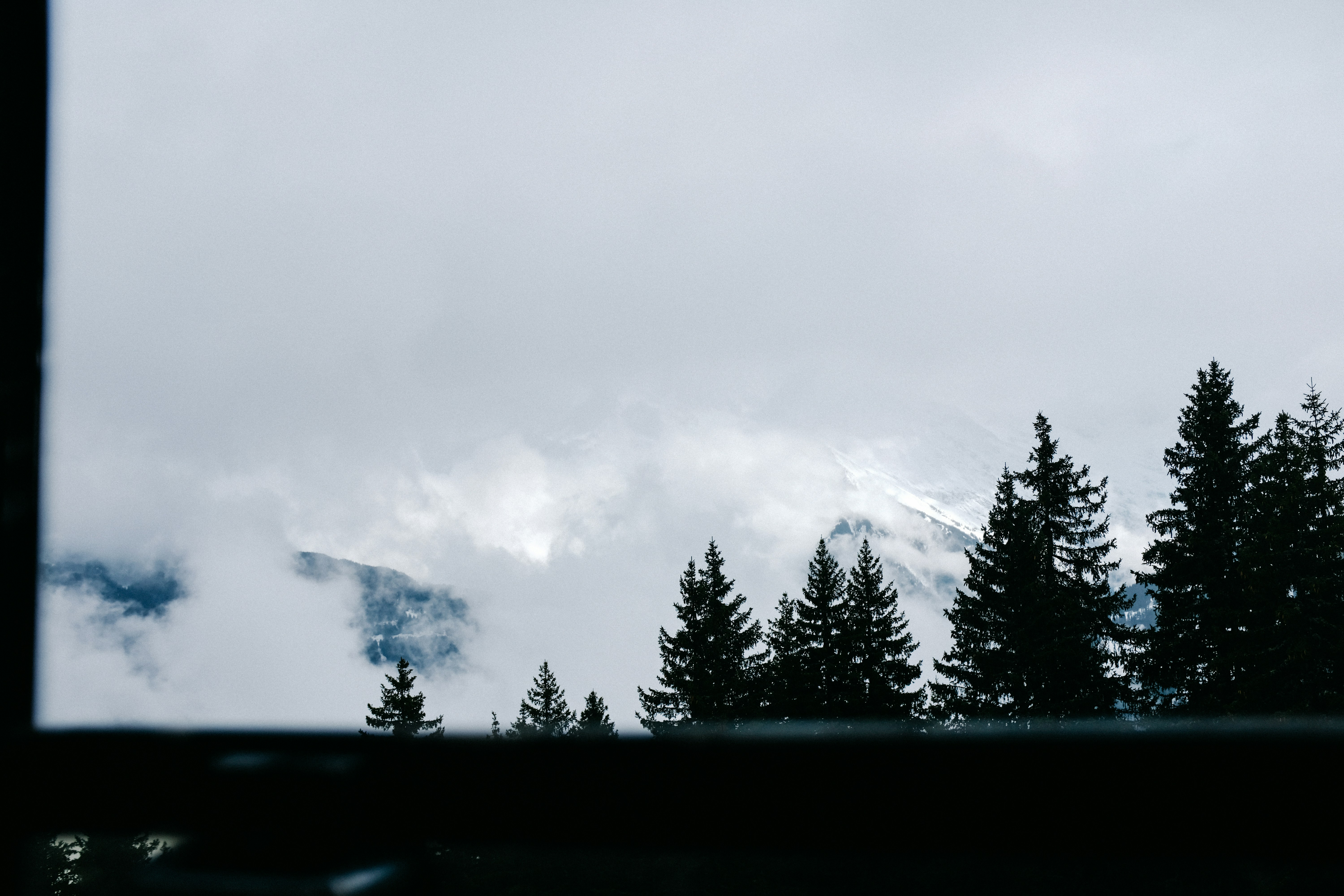 une vue d’une montagne à travers une fenêtre
