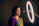 Portrait of a joyful Indian woman with flawless makeup in a softly lit luxury salon.
