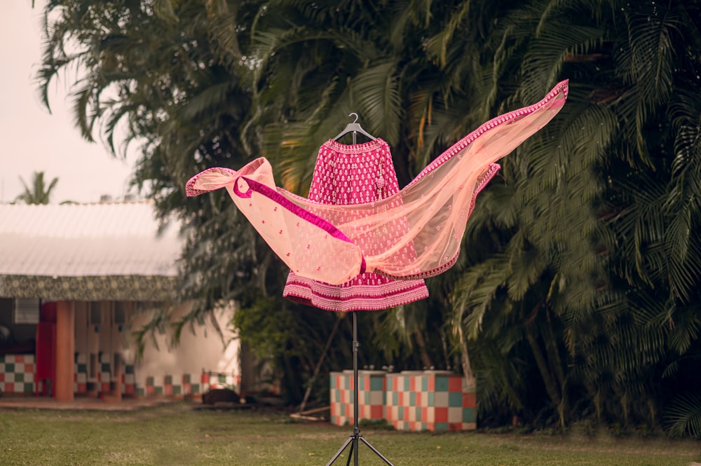 a pink umbrella with a bell on top of it