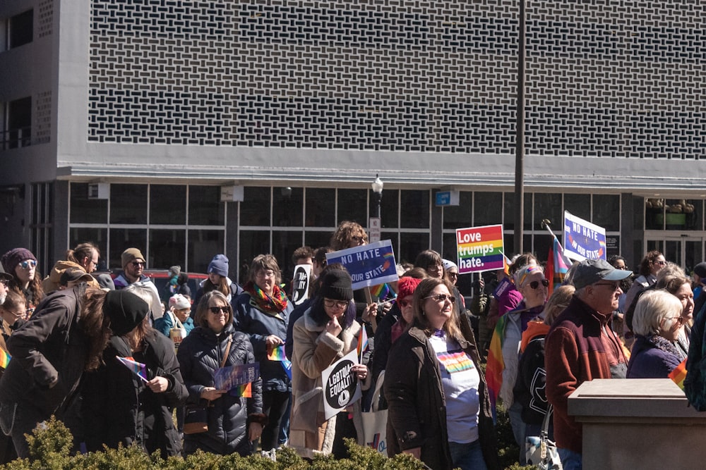 a crowd of people holding signs in front of a building