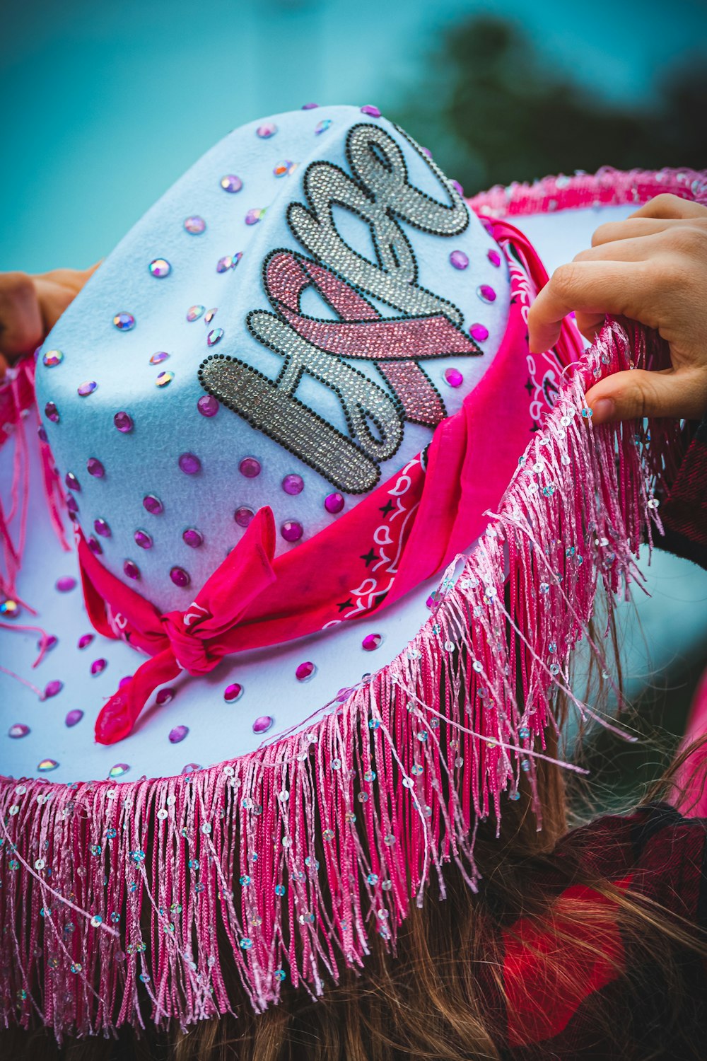 a woman wearing a pink and white hat with a name on it