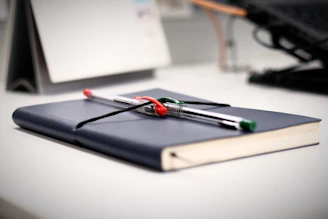 a notebook with a pair of scissors on top of it