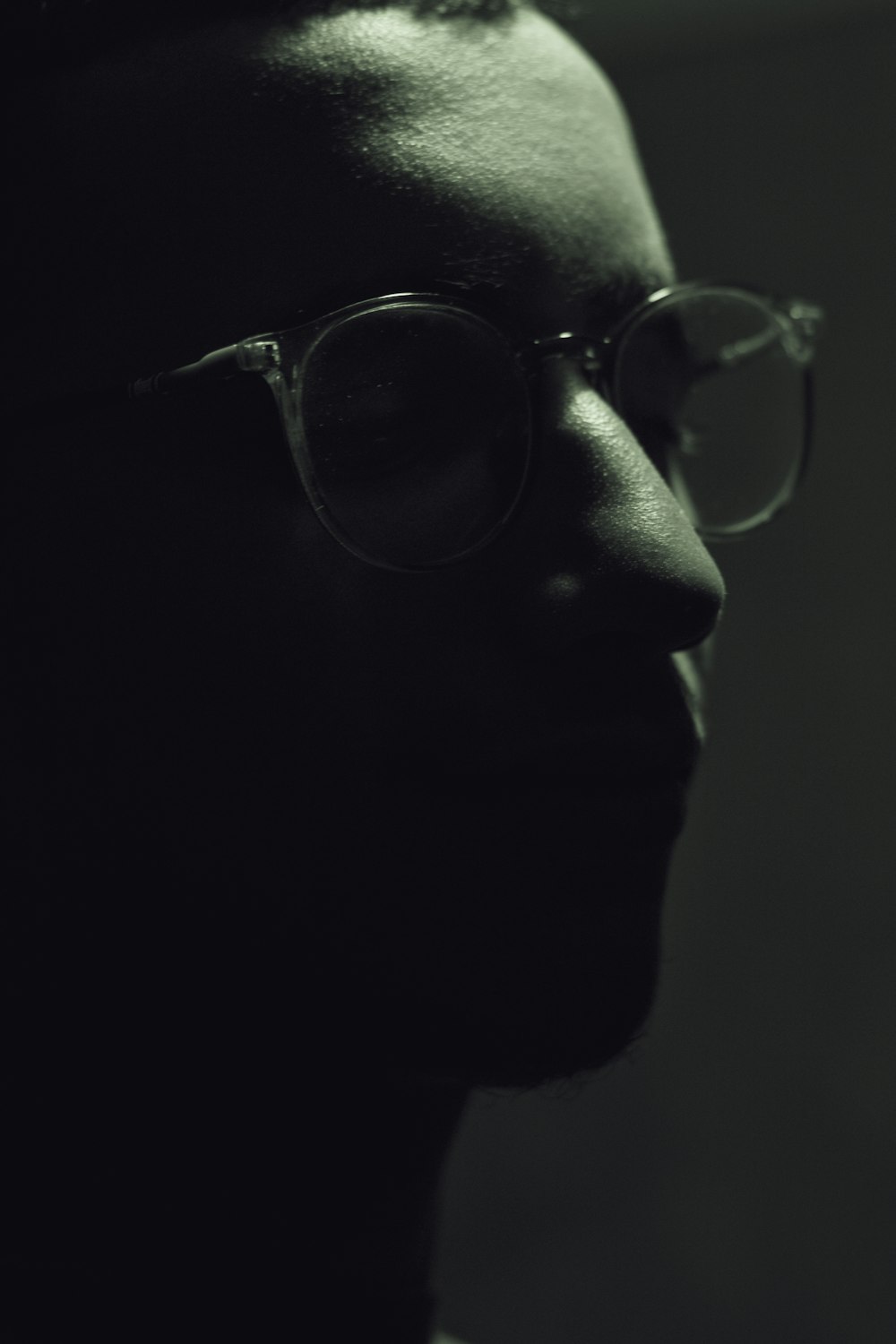 a man wearing glasses looking off into the distance