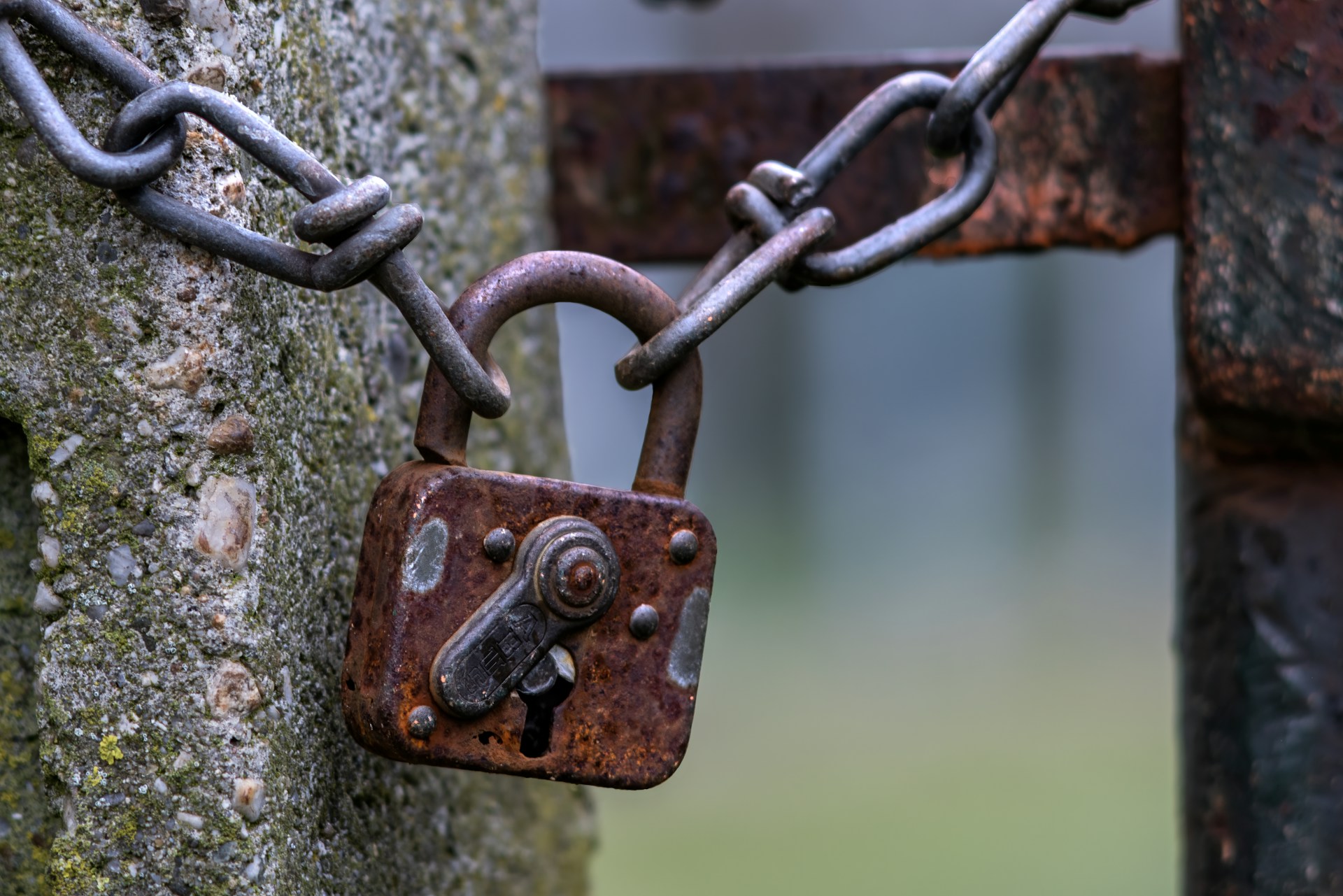 a rusted padlock attached to a stone wall