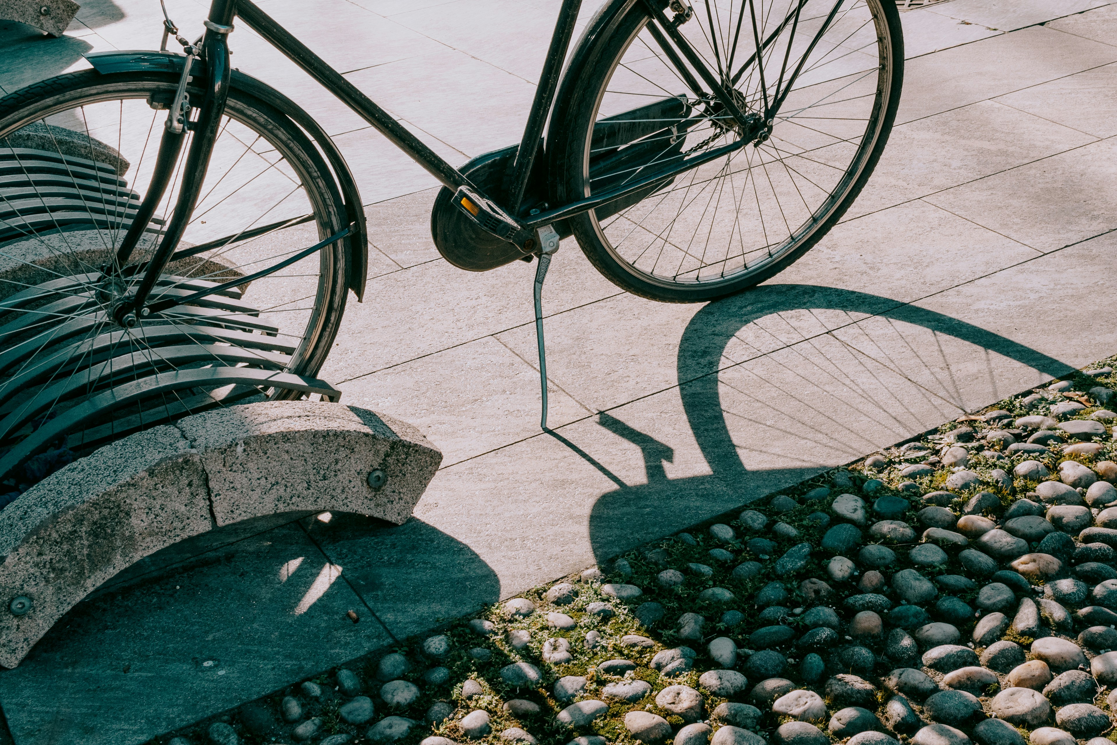 a bicycle parked next to a stone bench