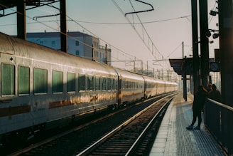 a person standing next to a train on a train track