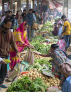A local market scene where fresh produce is being shared among neighbors.