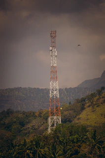 a tall tower sitting on top of a lush green hillside