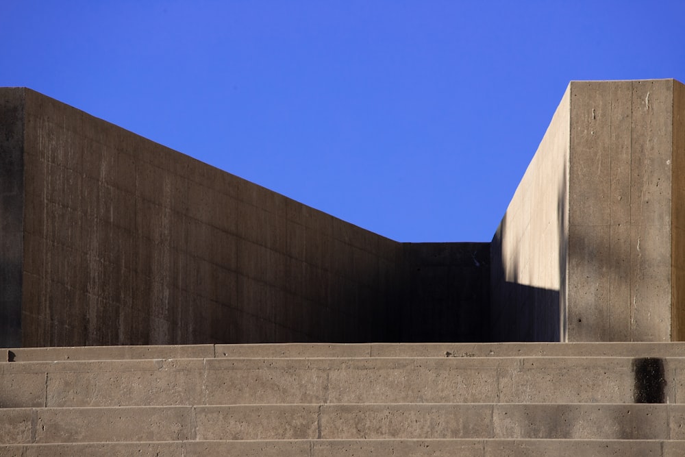 a concrete wall and steps against a blue sky