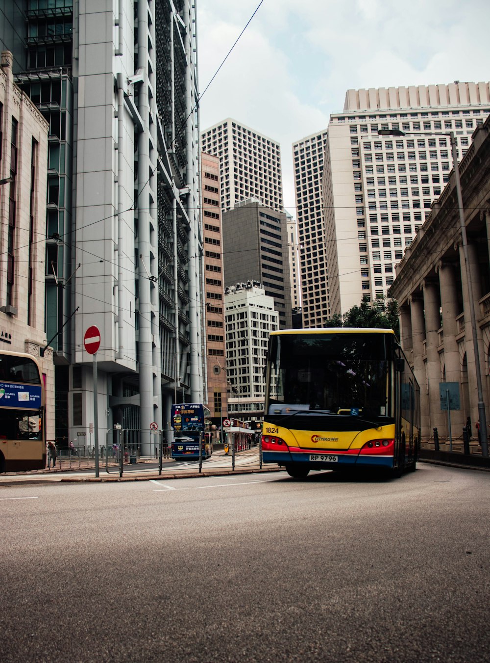 a bus driving down a street next to tall buildings