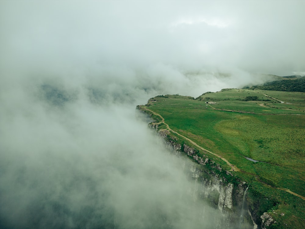 a large body of water surrounded by a lush green field