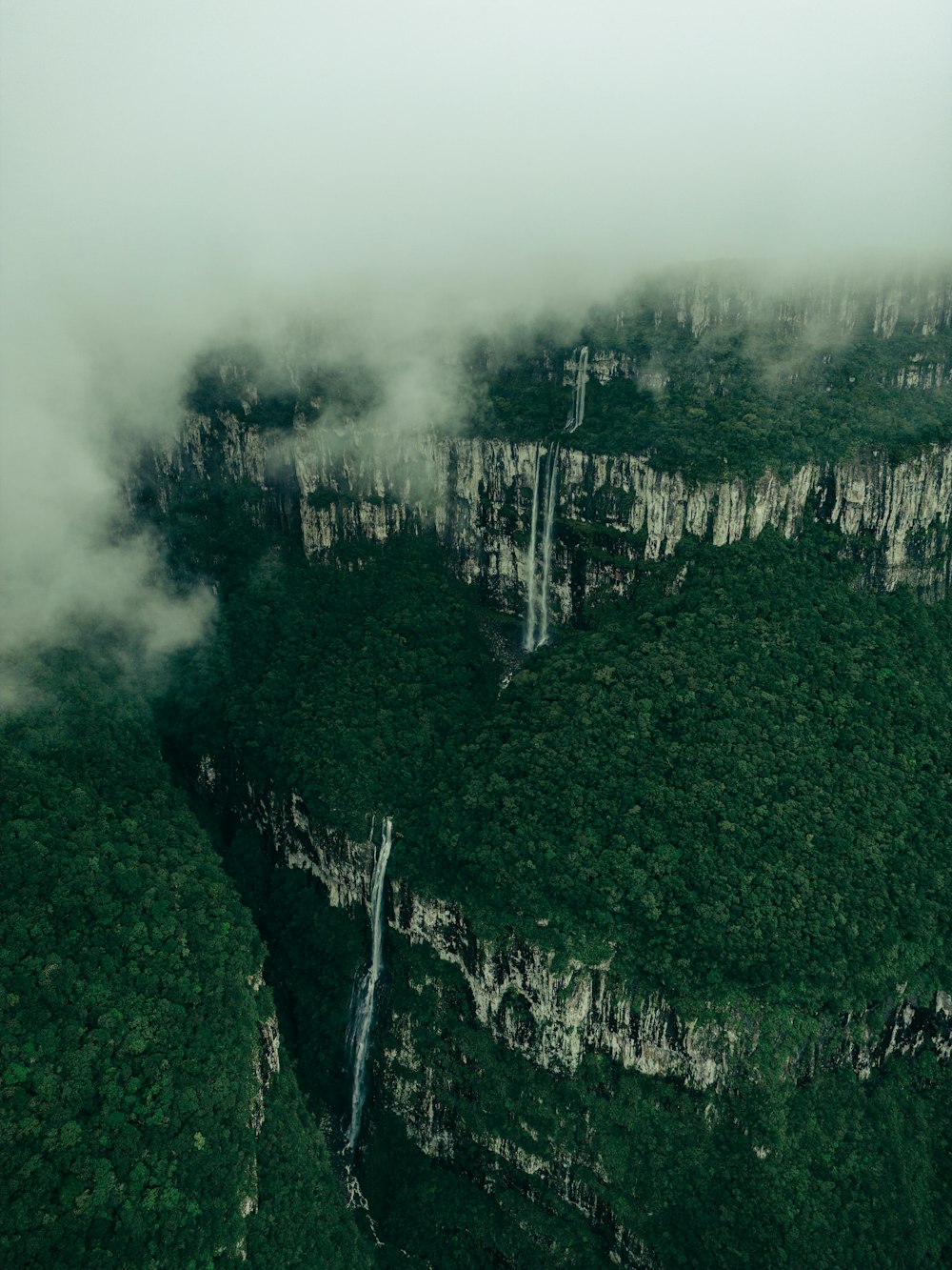 a very tall mountain with a waterfall in the middle of it